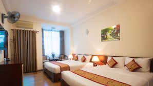 Une chambre d’hôtel avec deux lits, un bureau et une chaise.