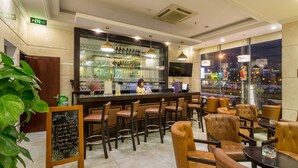 A bar area with a chalkboard menu, leather chairs, and a bartender. - Royal Family Hotel Da Nang (Da Nang)