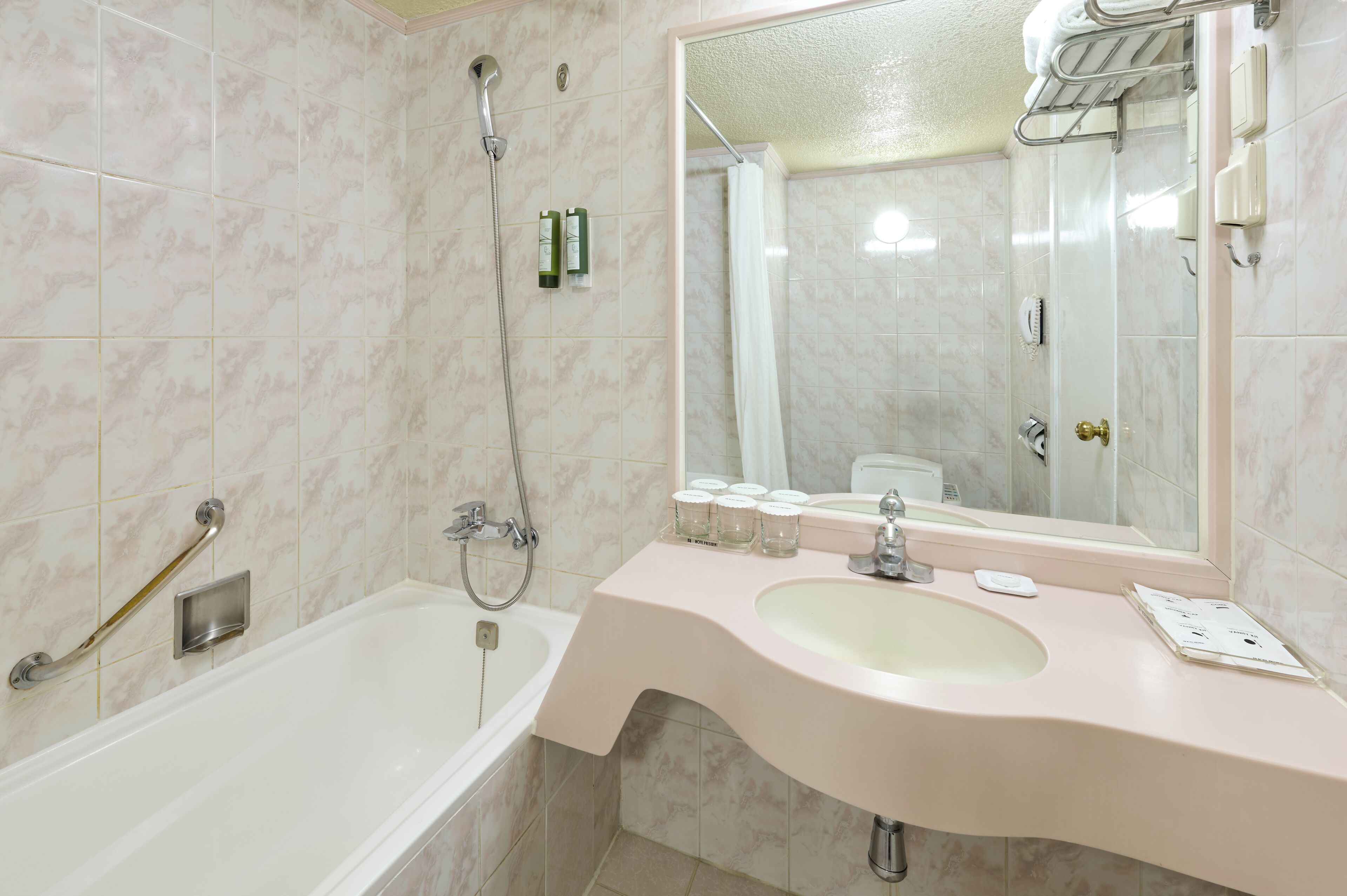Un baño con bañera, lavamanos, espejo y ducha.