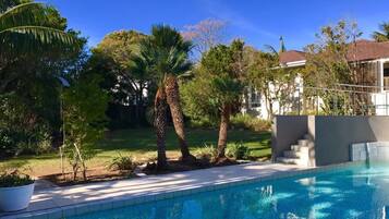 Una piscina al aire libre, tumbonas