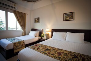 A hotel room with two beds, a window with curtains, a lamp, and two framed pictures on the wall. - Lao Golden Hotel (Vientiane)