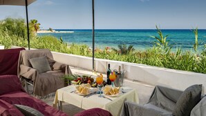 Une terrasse avec une table dressée pour un repas, donnant sur une plage.
