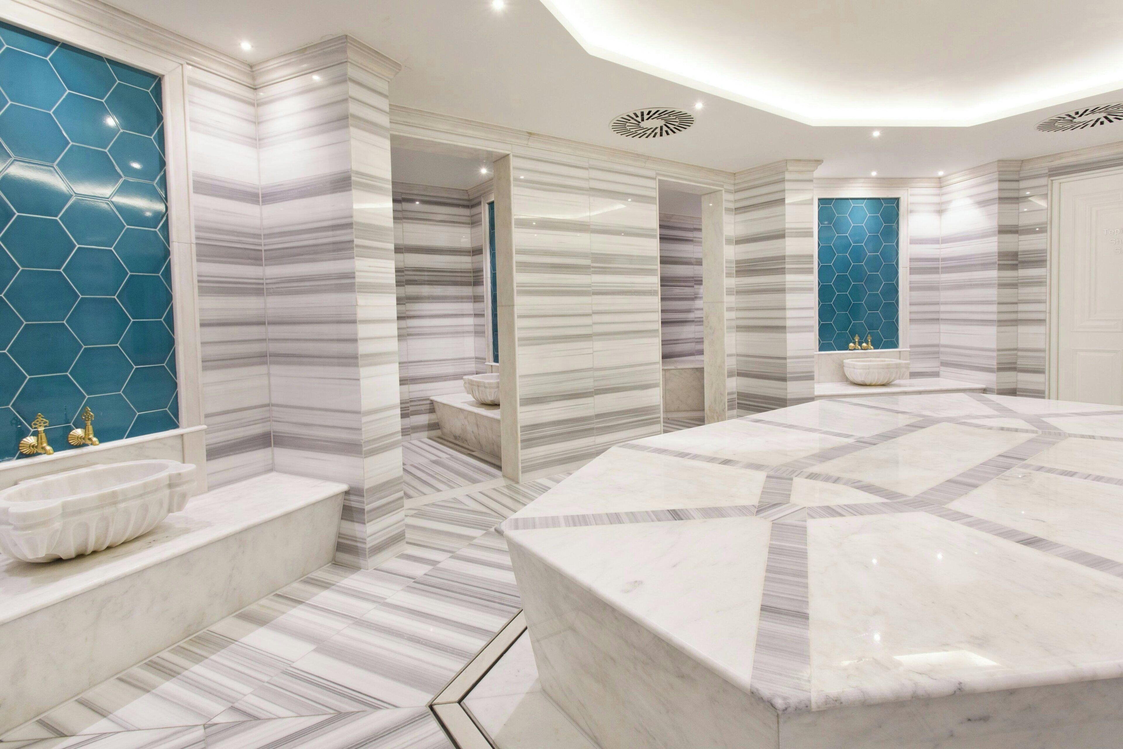 Une salle de bain moderne avec un grand lavabo en marbre, une baignoire et un espace douche.