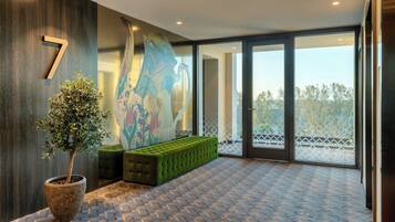 A modern lobby with a large number '7' on the wall, a green bench, and a potted plant.