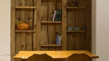 Una mesa de madera para comer con dos sillas frente a una estantería.