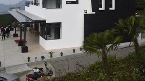 A modern multi-story building with a white and black facade, balconies, and a covered entrance area. - Alishan B&B Yunmingi Aliscenery (Zhuqi)