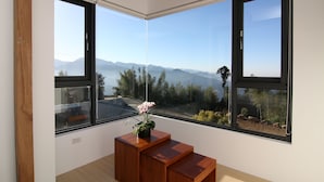 A room with large windows offering a mountain view, a wooden bench, and a potted plant. - Alishan B&B Yunmingi Aliscenery (Zhuqi)