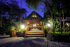 A wooden building with a thatched roof, a reception area, and a sign indicating a welcome reception. - Sweet Lake Resort (Naivasha)