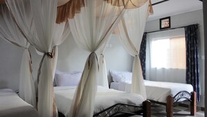 Ein Zimmer mit zwei Betten, jeweils mit weißer Bettwäsche und einem Baldachin.