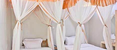 A room with two single beds, each with a canopy bedspread.