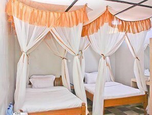 A room with two single beds, each with a canopy bedspread.
