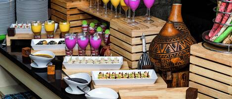 Disposición de bufé con diversas opciones de comida, bebidas y elementos decorativos.