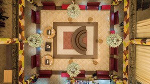 A top-down view of a hotel lobby with a central seating area, multiple tables, and decorative plants. - Lake Naivasha Resort (Naivasha)