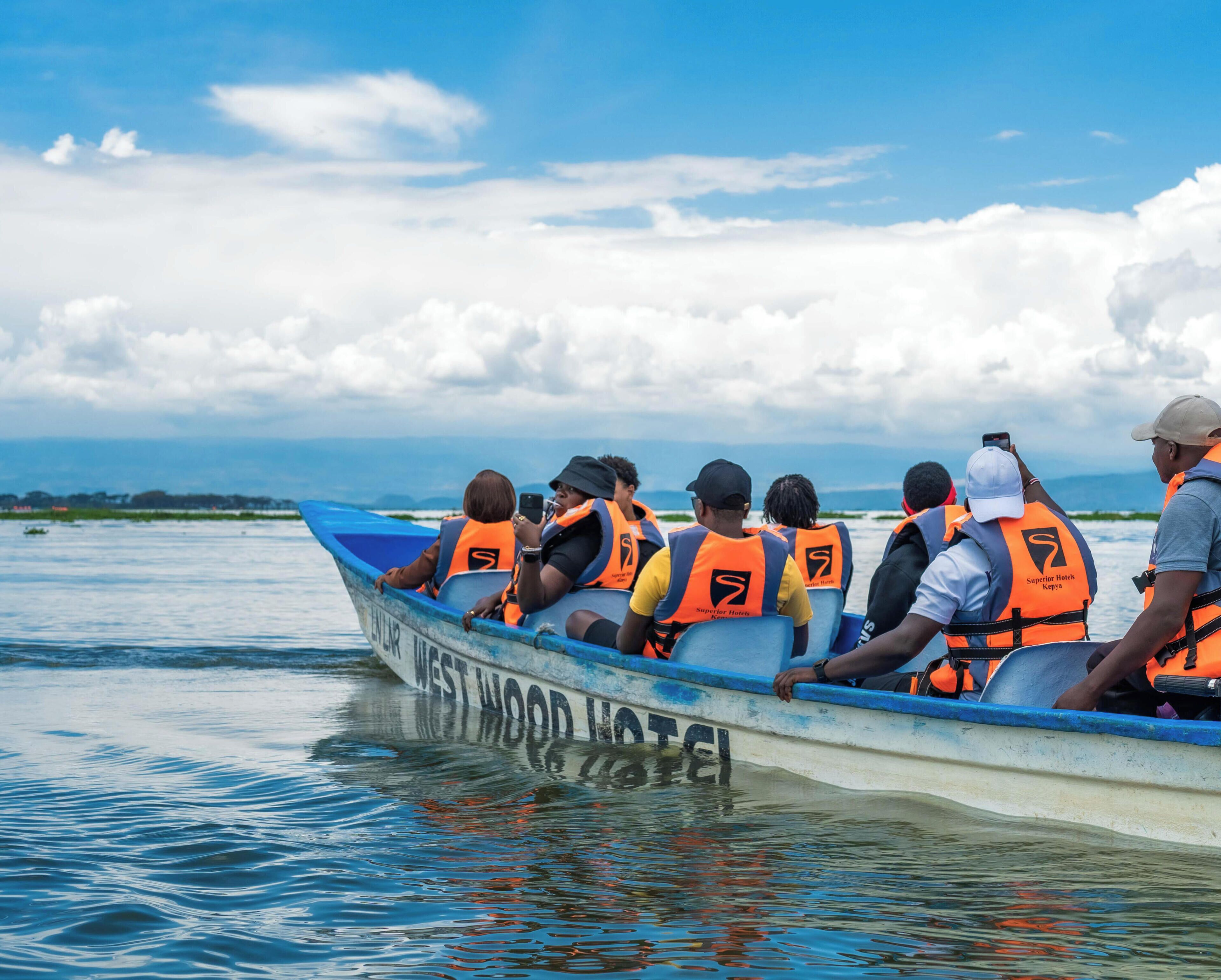 A boat with passengers wearing life jackets, labeled 'WESTWOOD HOTEL.'