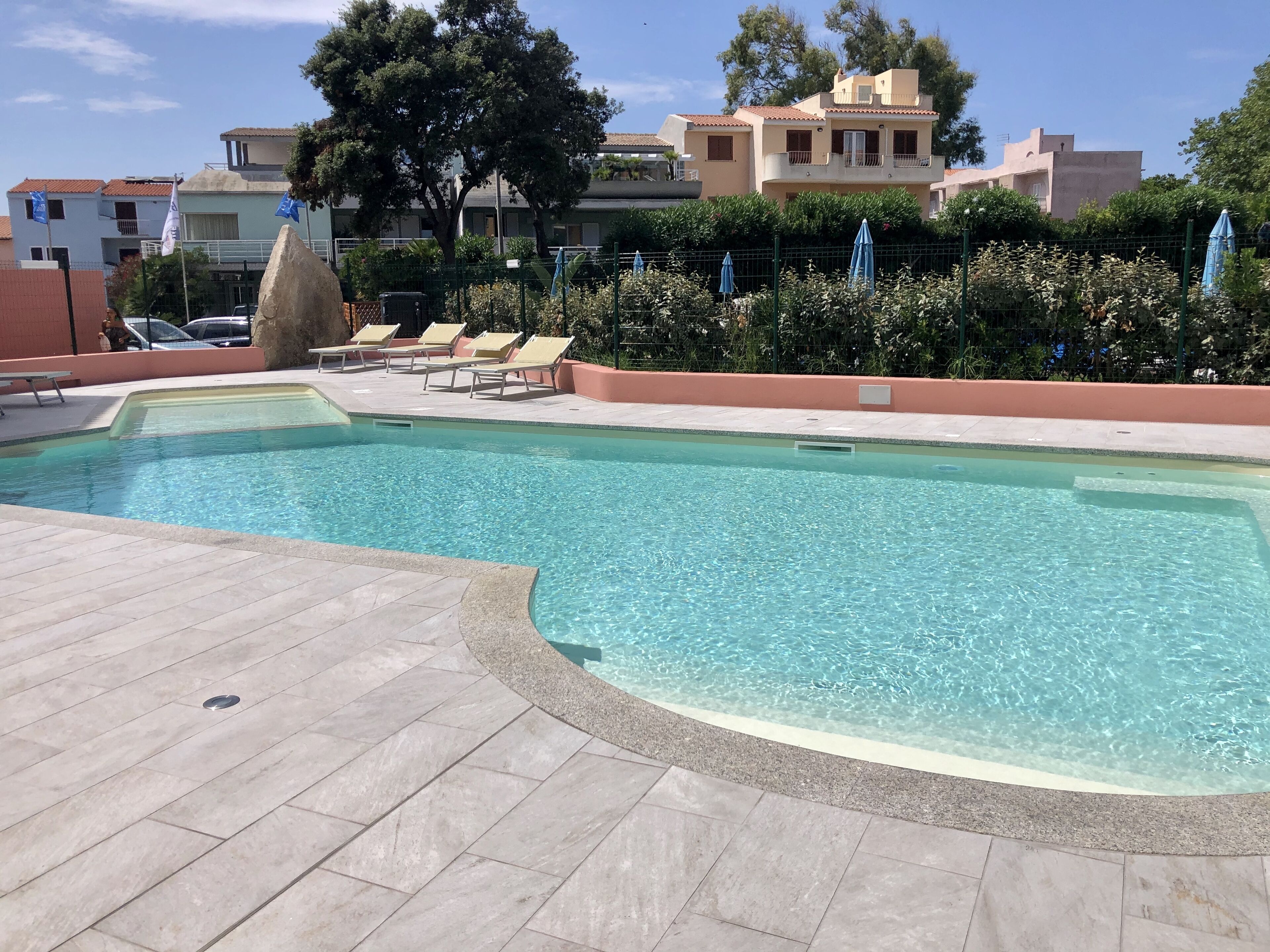 季节性开放的室外游泳池，池畔遮阳伞，日光浴躺椅