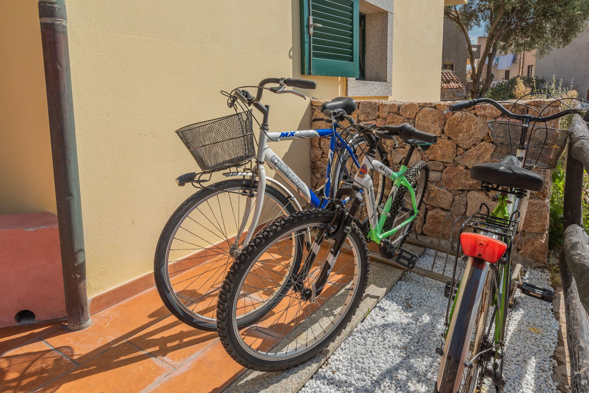 Uma bicicleta encostada a uma parede com uma cesta na frente.