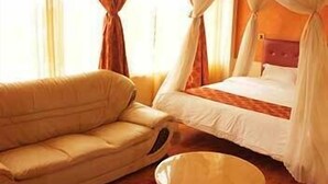 Quarto com uma cama, um sofá e uma mesa redonda.