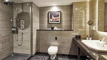 A modern bathroom with a shower, toilet, and sink.