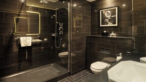 Un baño moderno con ducha de vidrio, inodoro y lavamanos.