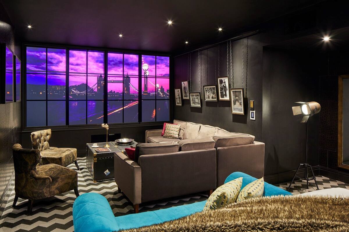 A modern living room with a large window, a sofa, armchairs, a coffee table, and a floor lamp.