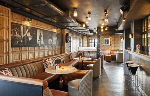 A modern interior with a bar area, seating, and artwork on the walls. - The Rex – Formerly Hotel Gotham (Manchester)