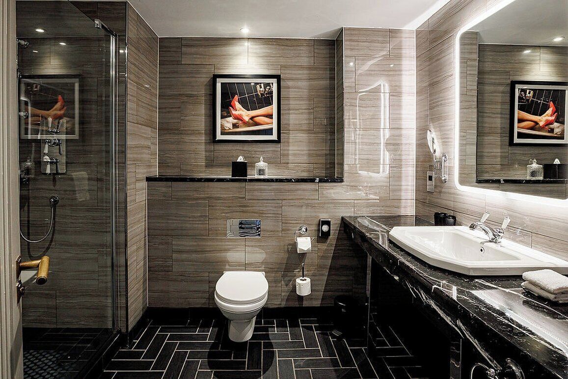 A modern bathroom with a shower, toilet, and sink.