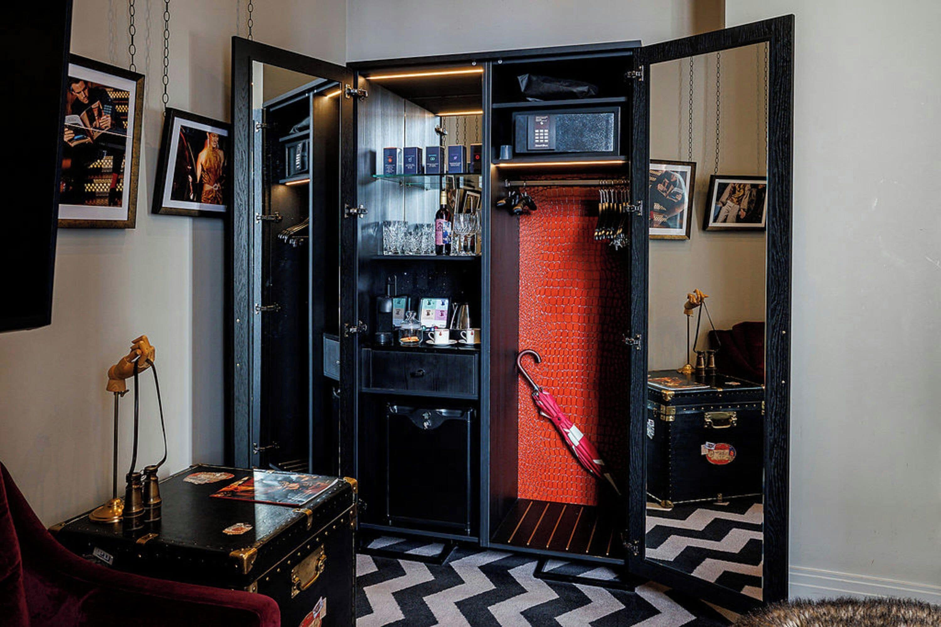 A room with a mirrored wardrobe, a red brick wall, and a black and white patterned floor.