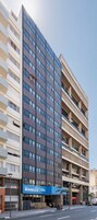 Un hotel moderno de varios pisos, con balcones y una entrada destacada.