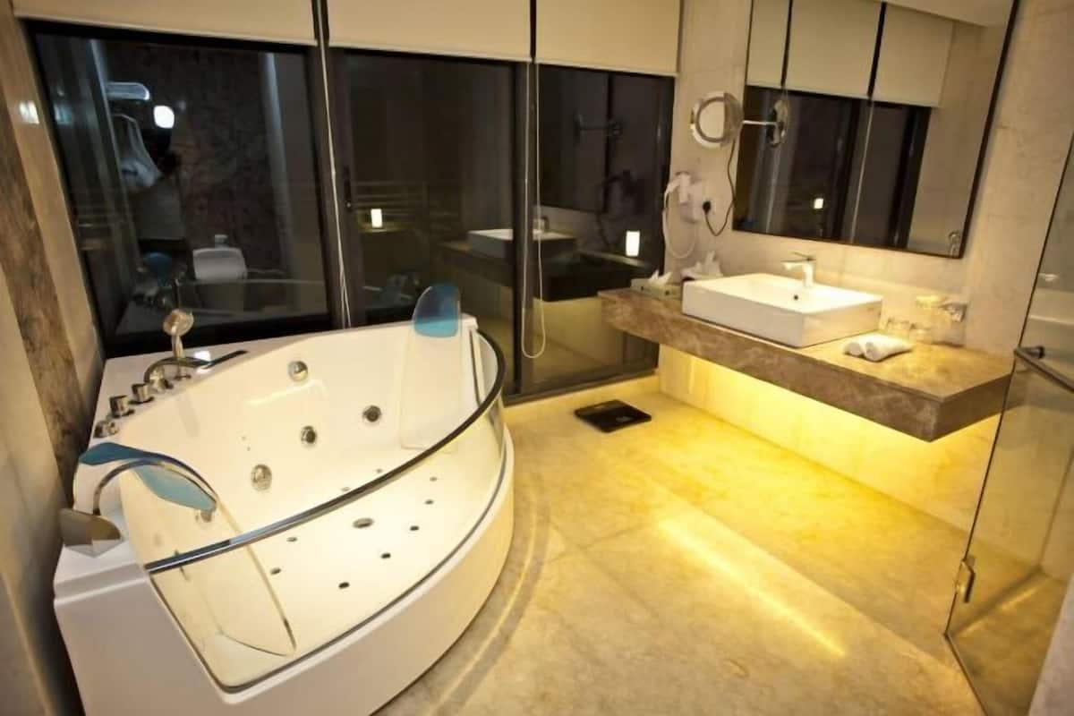 A modern bathroom with a freestanding bathtub, a vanity with a sink, and a large mirror.