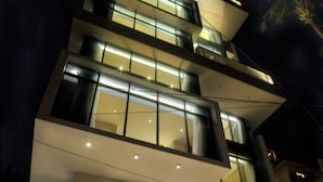 A modern hotel with a glass facade, multiple floors, and a well-lit entrance. - Lakeshore Banani (Dhaka)