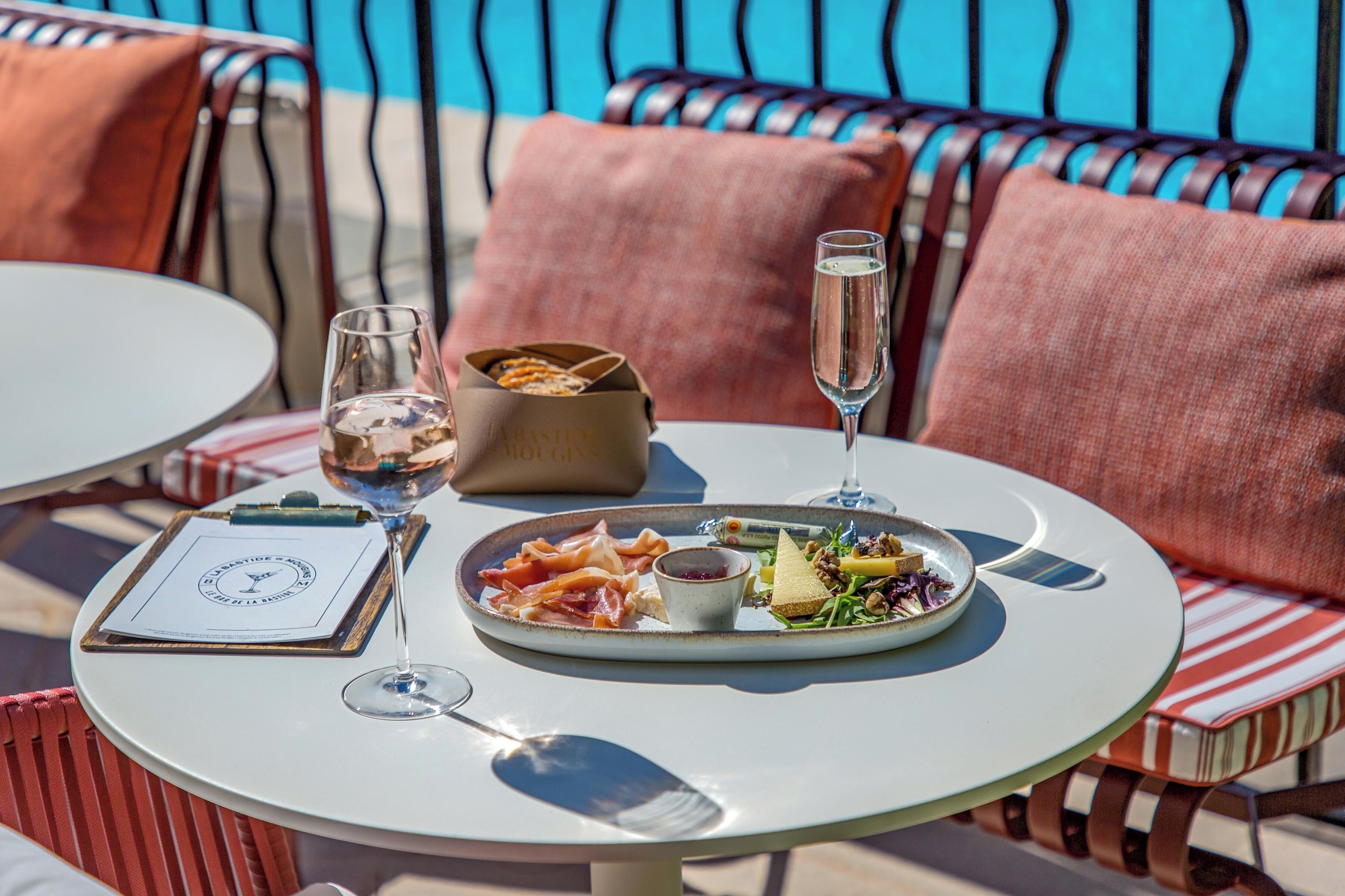 A round table with a plate of food, a glass of water, and a menu.