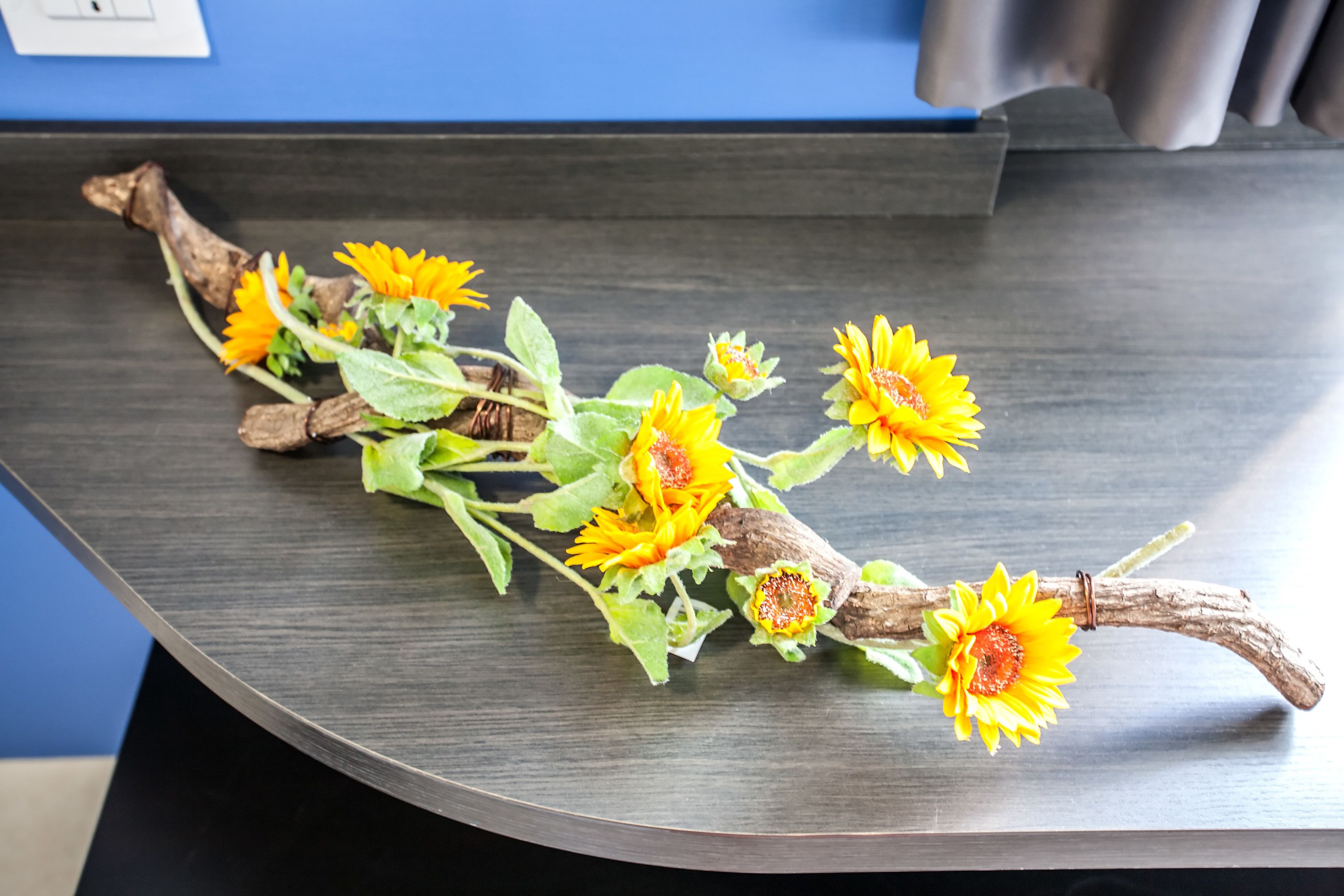 A wooden surface with branches and yellow flowers.
