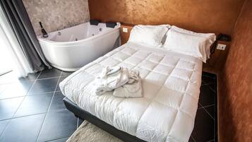 Ein Hotelzimmer mit einem großen Bett, einer separaten Badewanne und einem Telefon an der Wand.