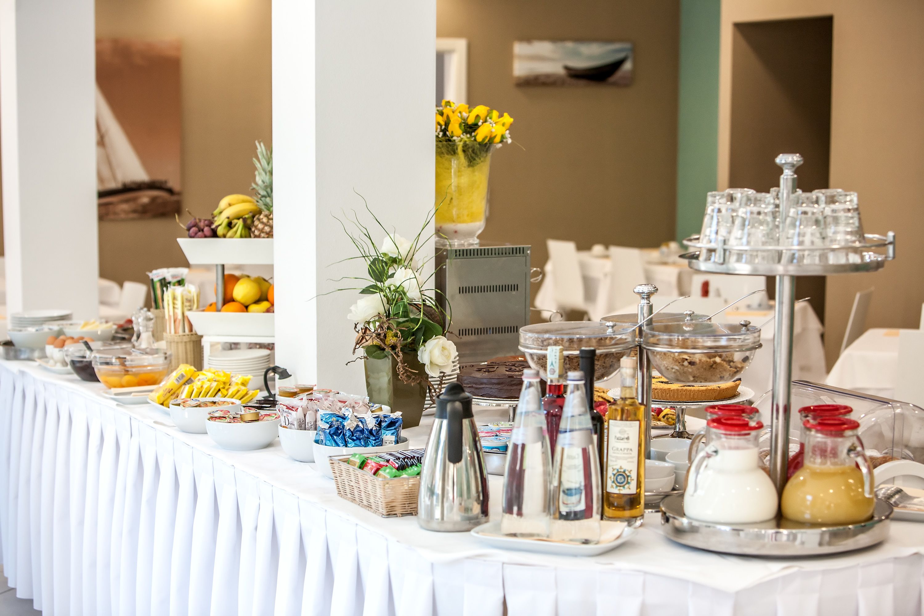 Una mesa de buffet con diversos alimentos, salsas y una estación de bebidas.