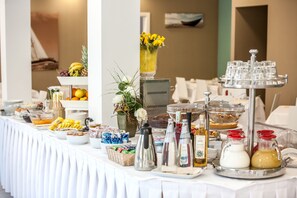 Une table de buffet proposant divers plats, accompagnements et une sélection de boissons.