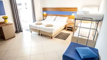A hotel room with a bed, a bunk bed, a desk, and a small cabinet.