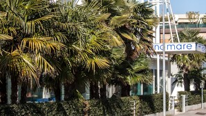 Un edificio moderno de varios pisos, con amplios ventanales y una señal de calle que dice "no mare".