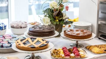 A buffet table with various desserts and pastries, including cakes and pies, arranged on stands.