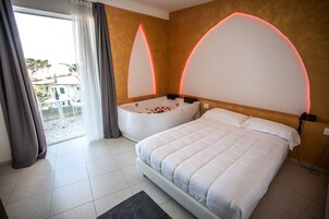 Un dormitorio con una cama grande, una bañera y vistas al exterior.