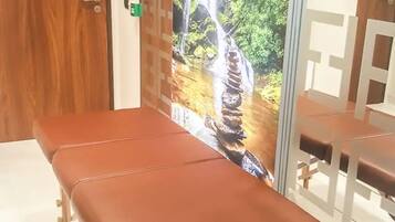A room with a wooden door, a bench, and a wall with a waterfall mural.
