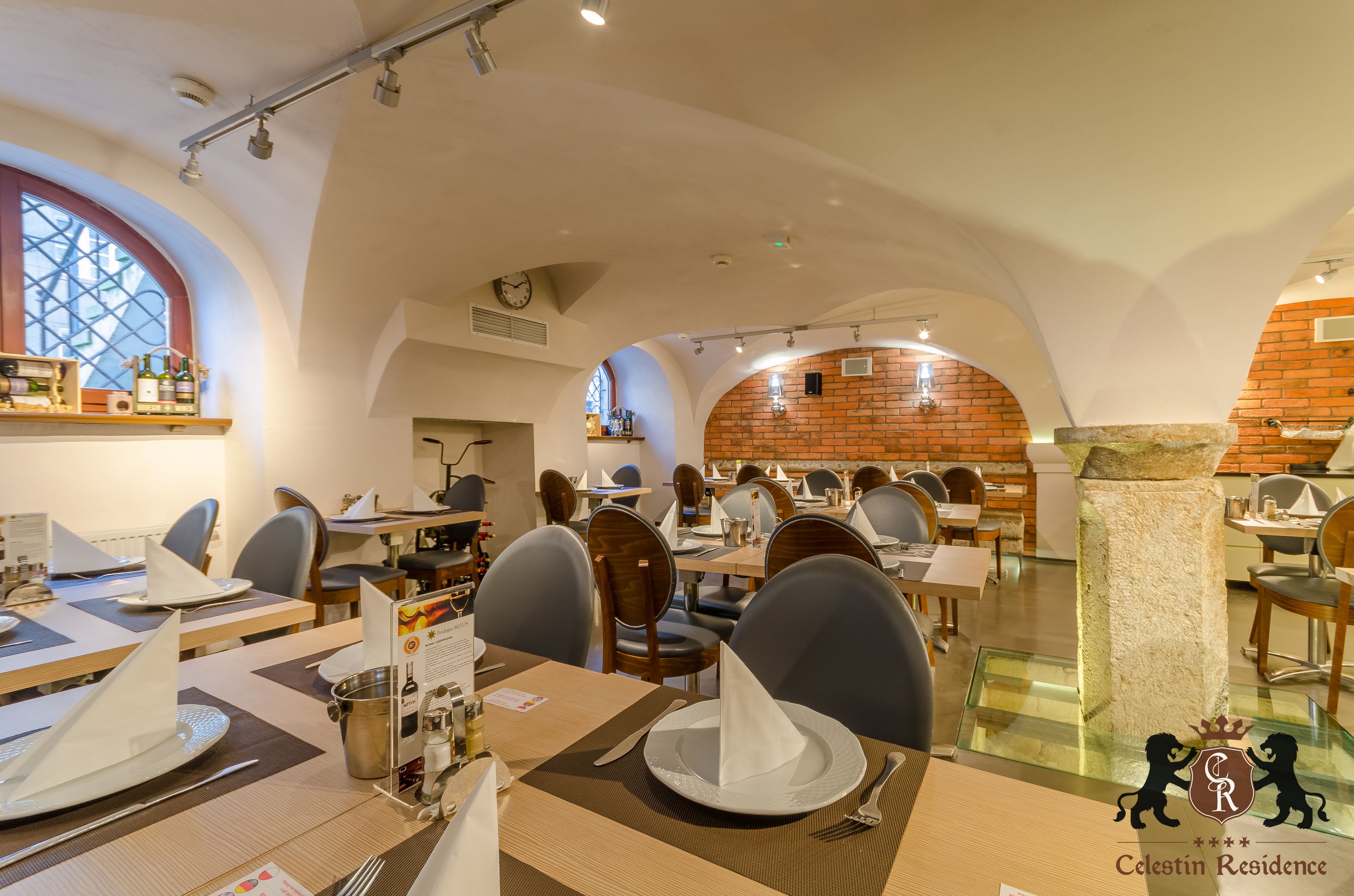 Ein Restaurant mit hohen Gewölbedecken, Backsteinwänden und verschiedenen Sitzmöglichkeiten, darunter Tische und Stühle.