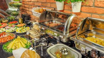 A buffet with various food items including salads, meats, and bread.