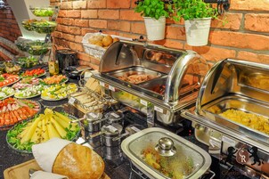 A buffet with various food items including salads, meats, and bread.