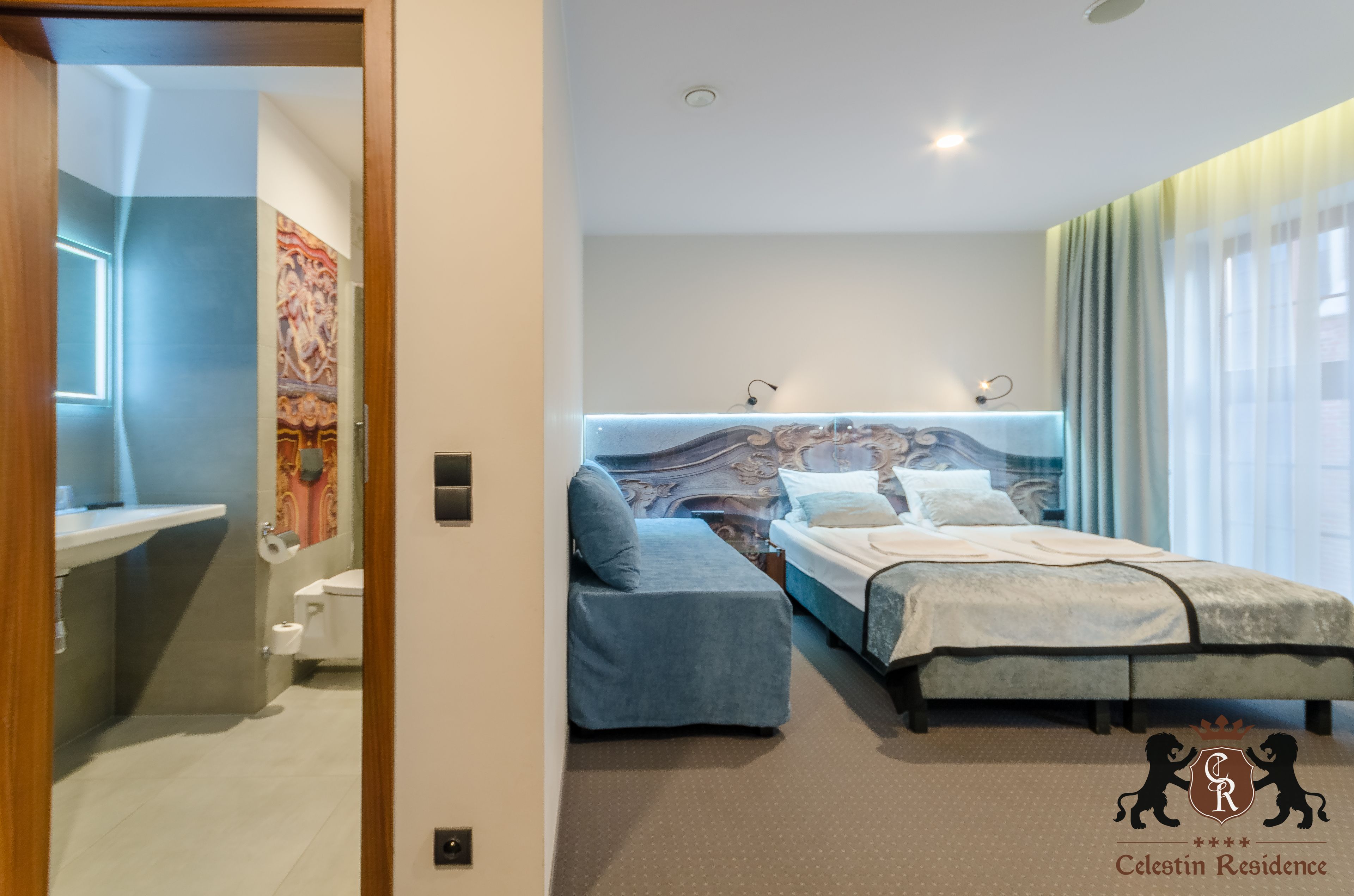A modern bedroom with a bed, a sofa, and a bathroom.