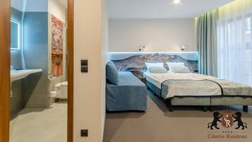 A modern bedroom with a bed, a sofa, and a bathroom.