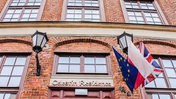 A brick building with the sign "Celsin Residence" and two flags, one with stars and one with a Union Jack.