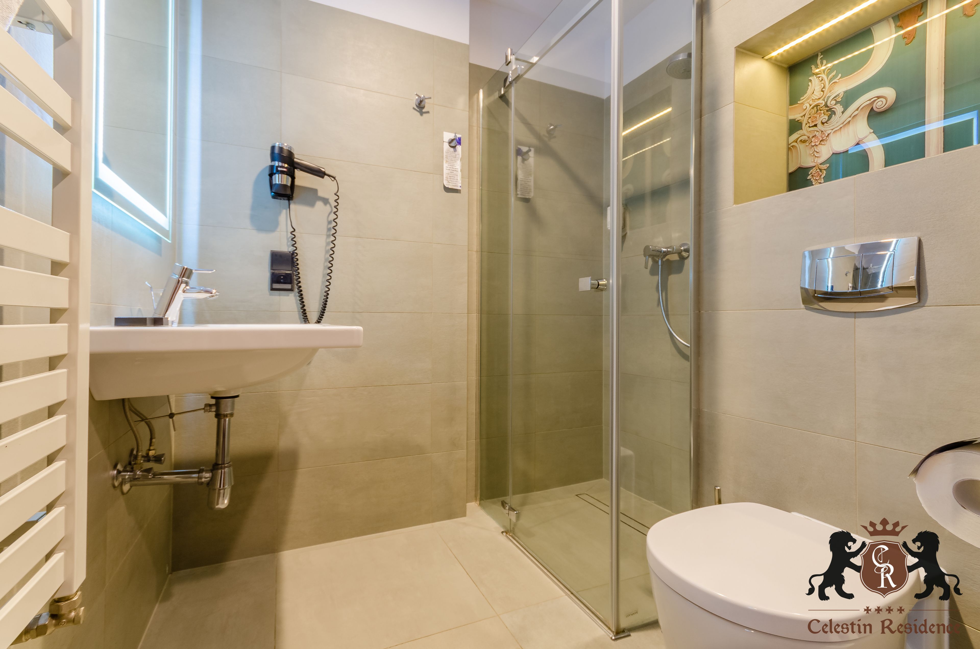 A modern bathroom with a glass shower enclosure, a white sink, and a toilet.