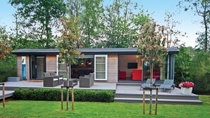 A modern house with a patio area featuring outdoor furniture and a small garden.
