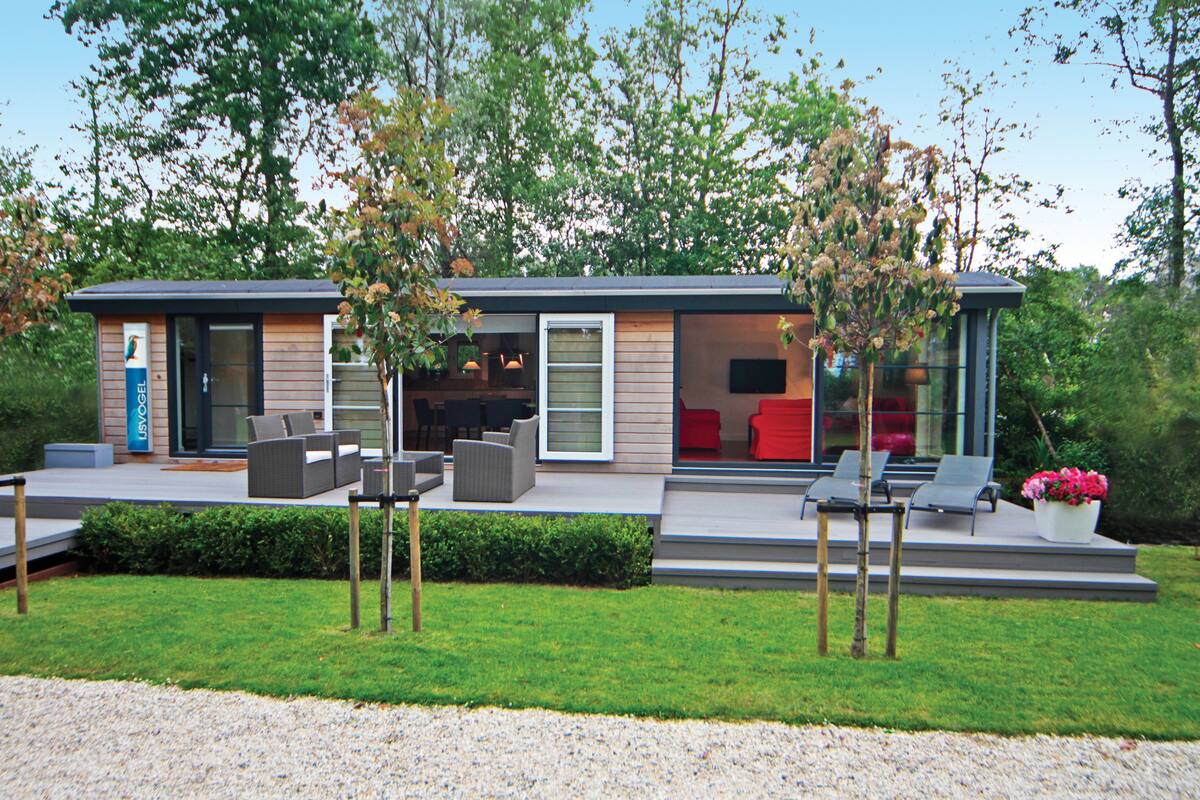 A modern house with a patio area featuring outdoor furniture and a small garden.