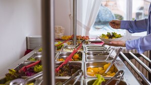 Tarjolla on runsas buffet, jossa on monipuolinen valikoima ruokia ja ruokailuvälineitä.